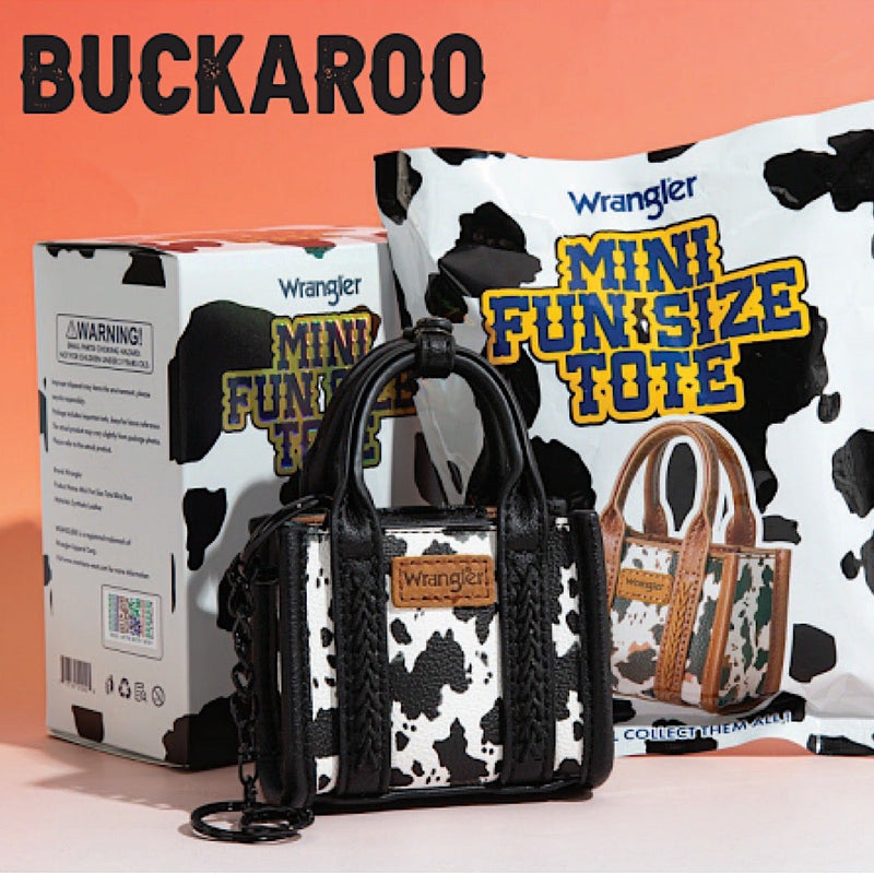 Cow print handbag with Wrangler branding in front of a cow print box.