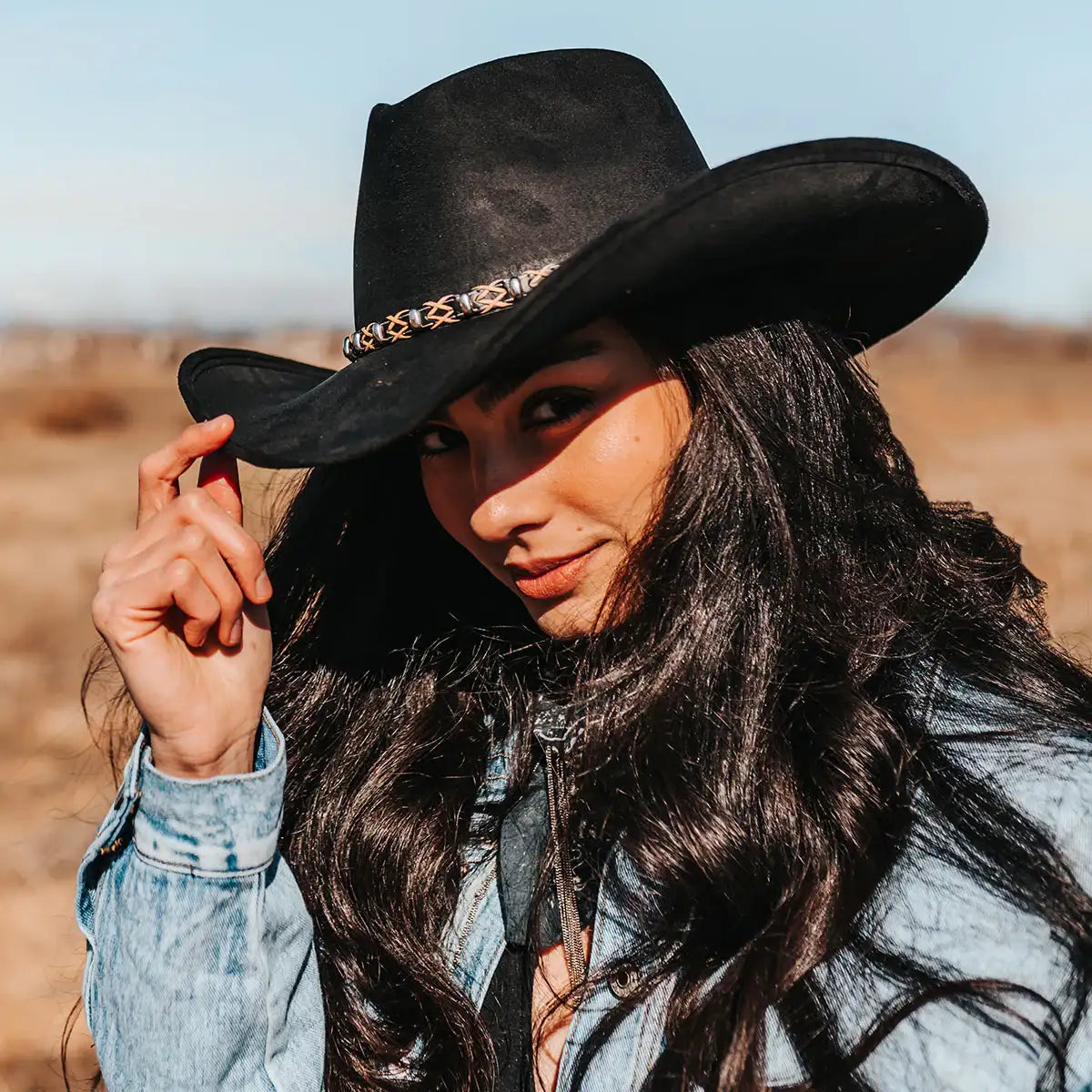 Black suede cowboy hat with a decorative metal band