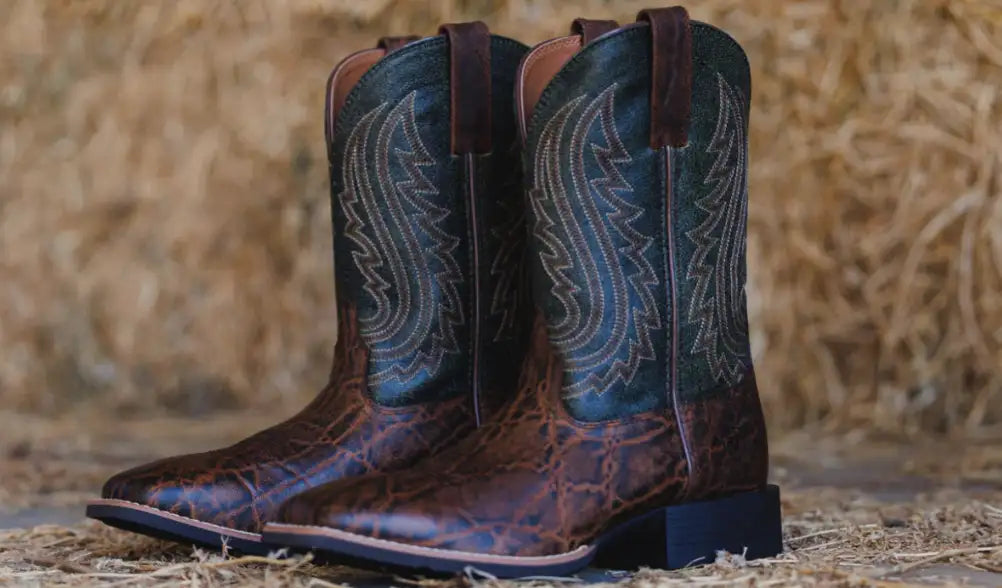 Brown crocodile-patterned cowboy boots with teal and silver wing embroidery.
