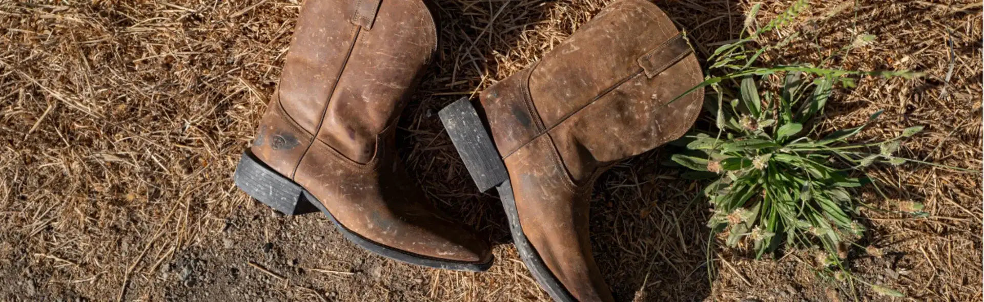 Brown leather cowboy boots with black rubber soles and a classic western design.