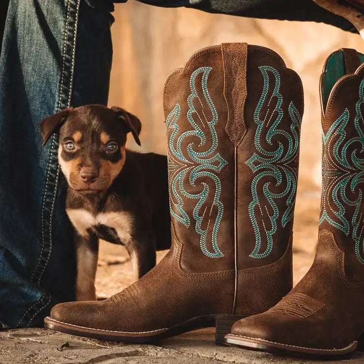 Brown leather cowboy boots with teal embroidered designs.