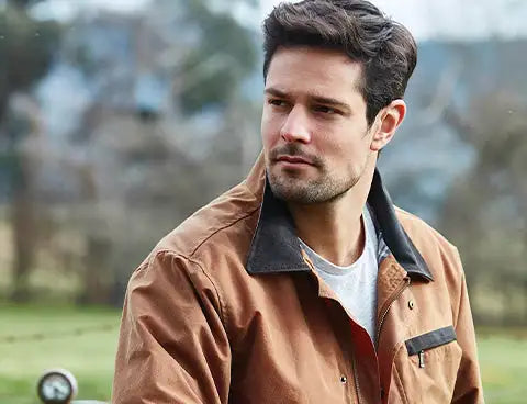 A brown leather jacket with a black collar and flap pockets.