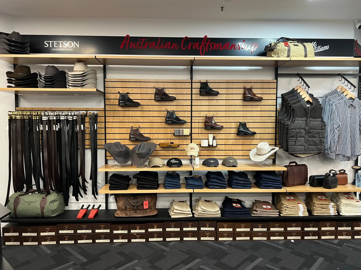 A brown leather stetson hat displayed on a wooden shelf in an australian craftsmanship store.