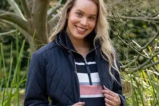 Dark blue quilted jacket with a zipper collar and striped inner shirt.