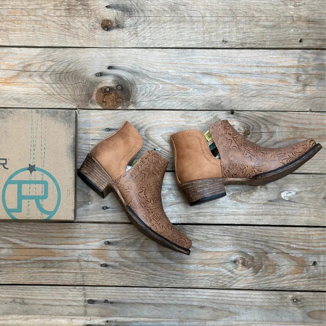 Tan leather cowboy boots with intricate floral embossing and a low block heel.