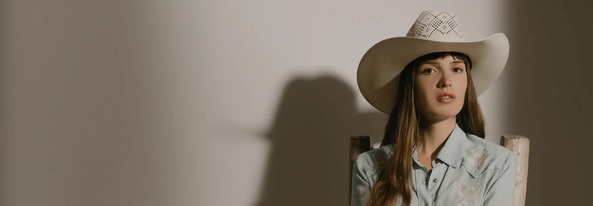 A white cowboy hat with a woven, patterned band.